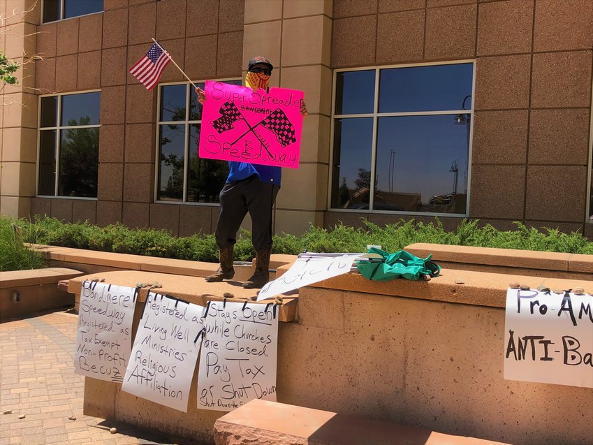 An opponent of recent racing events at Bandimere Speedway protests outside the Jefferson County Building on March 8.